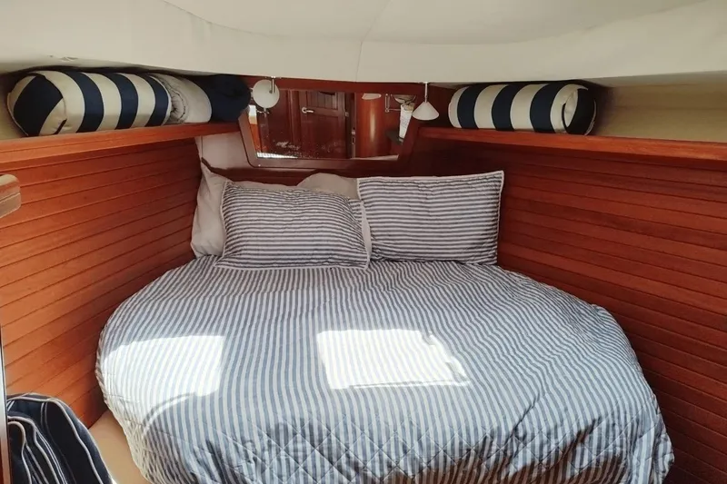 Slide: The Image of Cozy cabin interior of 2009 Hunter 50 Center Cockpit with striped bedding and wooden paneling. - 11