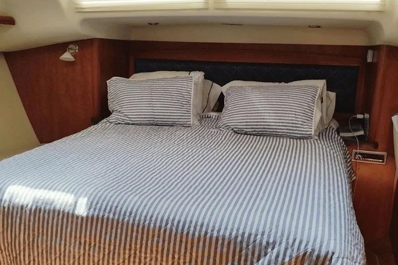 Slide: The Image of Cozy cabin bedroom in 2009 Hunter 50 Center Cockpit yacht with striped bedding. - 12