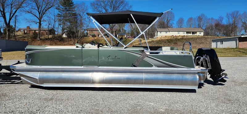 Slide: The Image of 2024 Avalon Platinum LSZ 2385 Elite pontoon boat with canopy, parked on gravel. - 5