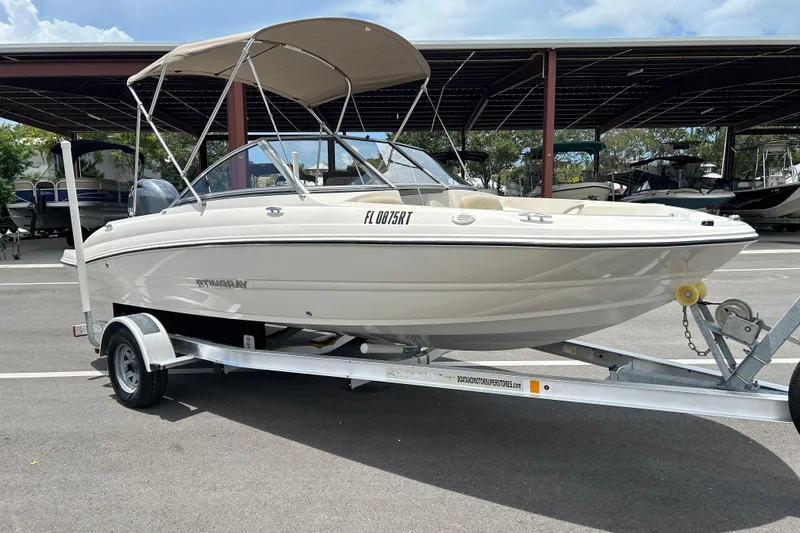 The Image of 2018 Stingray 191 DC boat on trailer, parked in marina lot. - 0