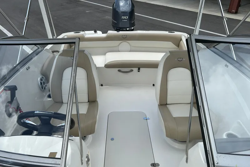 Slide: The Image of 2018 Stingray 191 DC boat interior with beige and white seating, steering wheel, and windshield. - 11