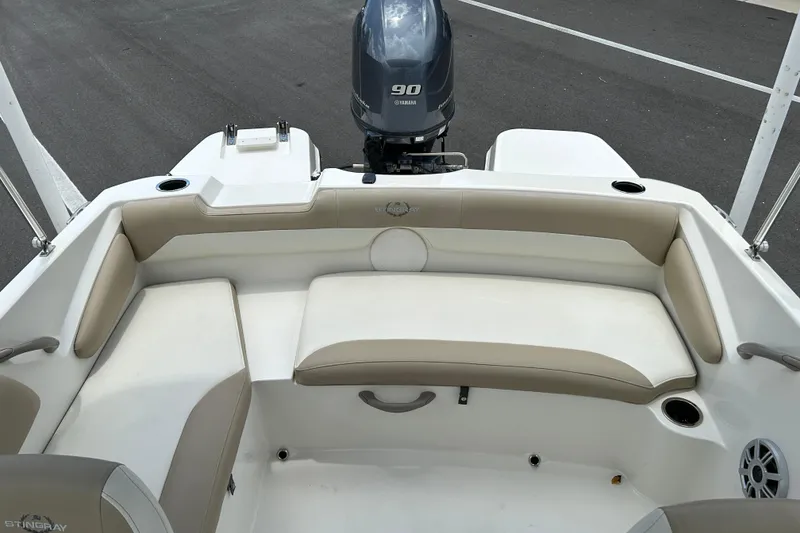 Slide: The Image of 2018 Stingray 191 DC boat interior with beige seating and Yamaha 90 engine. - 12