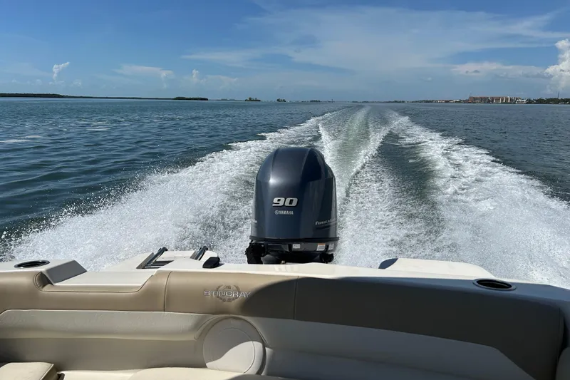 Slide: The Image of 2018 Stingray 191 DC boat cruising on open water with Yamaha outboard motor. - 19
