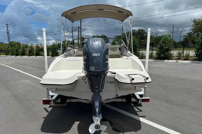 Slide: The Image of 2018 Stingray 191 DC boat with Yamaha 90 engine, parked on a trailer. - 2
