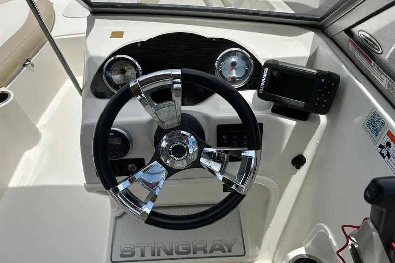 Slide: The Image of 2018 Stingray 191 DC boat dashboard with steering wheel, gauges, and navigation system. - 8