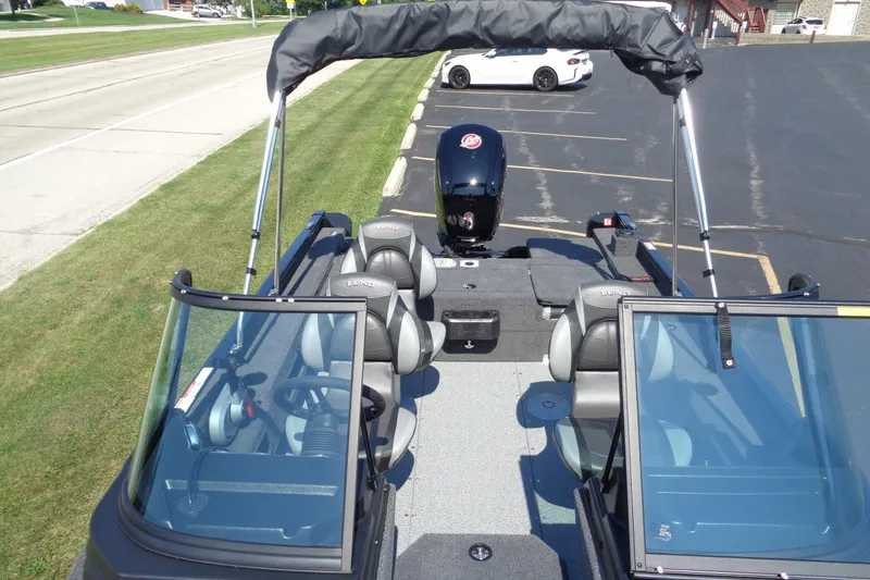 Slide: The Image of 2025 Lund 1775 Adventure Sport boat with seating and motor, parked on pavement. - 8