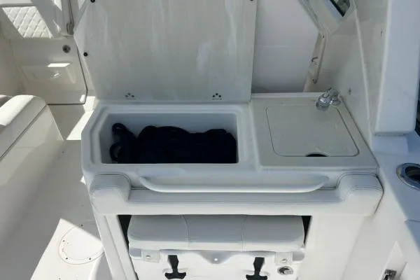 Slide: The Image of 2019 Edgewater 262 CX boat interior with storage compartment and sink. - 12