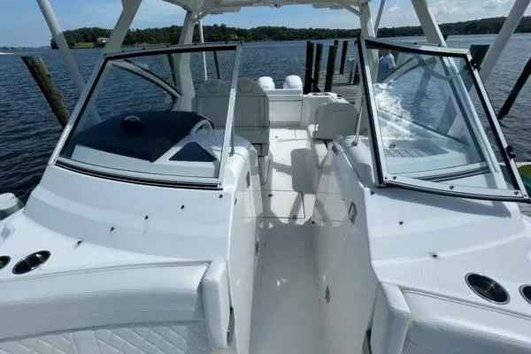 Slide: The Image of 2019 Edgewater 262 CX boat interior with open cockpit, white seating, and waterfront view. - 14