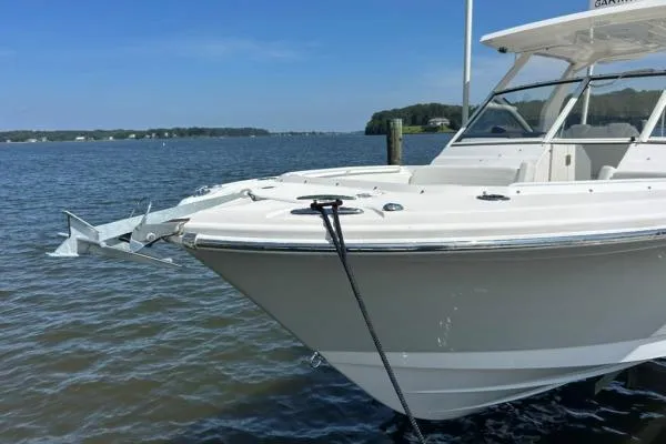 Slide: The Image of 2019 Edgewater 262 CX boat docked on calm water under clear blue sky. - 19