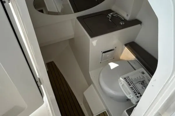 Slide: The Image of 2019 Edgewater 262 CX boat interior with compact bathroom and sink. - 4