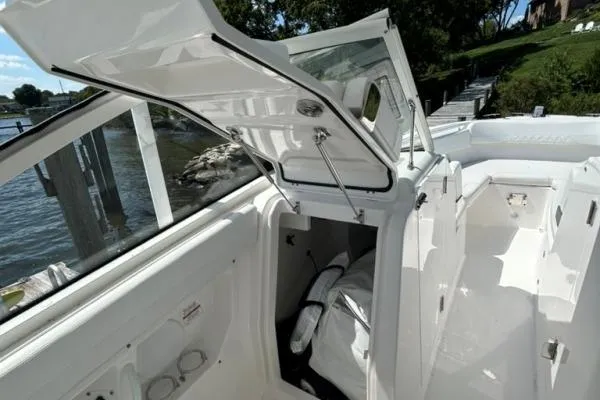 Slide: The Image of 2019 Edgewater 262 CX boat interior with open storage compartment by the water. - 5