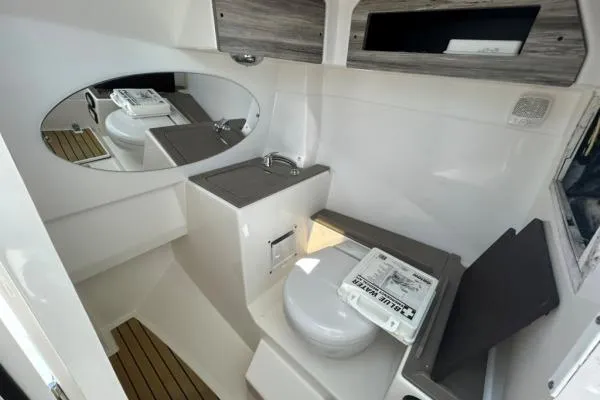 Slide: The Image of 2019 Edgewater 262 CX boat interior with toilet, sink, and mirror. - 6