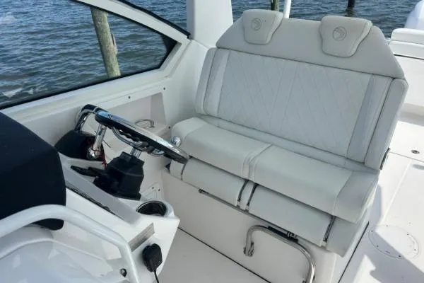 Slide: The Image of 2019 Edgewater 262 CX boat interior with white seating and steering wheel. - 7