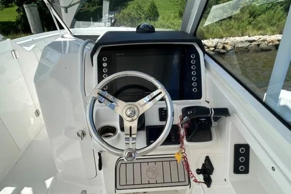 Slide: The Image of 2019 Edgewater 262 CX boat cockpit with steering wheel and control panel. - 9