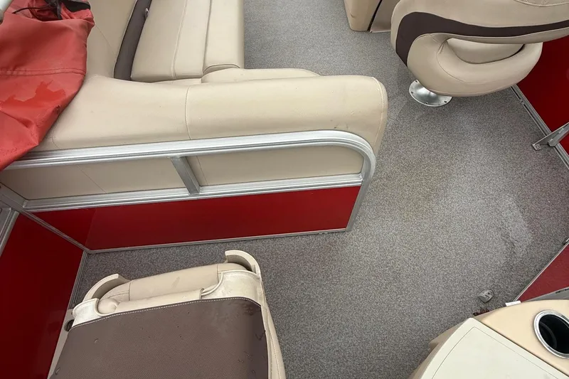 Slide: The Image of 2017 Sun Tracker Bass Buggy 18 DLX interior with beige seating and red accents. - 11