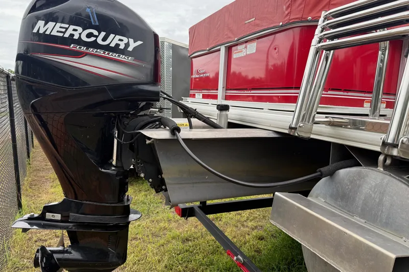 Slide: The Image of 2017 Sun Tracker Bass Buggy 18 DLX with Mercury FourStroke engine, parked on grass. - 2