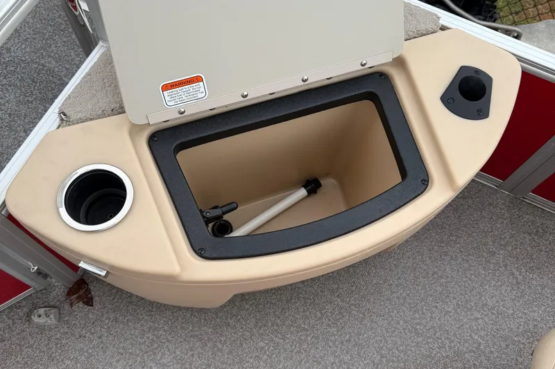 Slide: The Image of 2017 Sun Tracker Bass Buggy 18 DLX storage compartment with cup holders and warning label. - 5