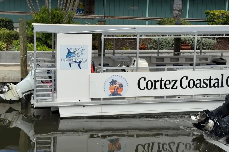 Slide: The Image of 2022 Guthrie Boatworks A&M Custom Pontoon docked, featuring Cortez Coastal Cruises signage. - 13
