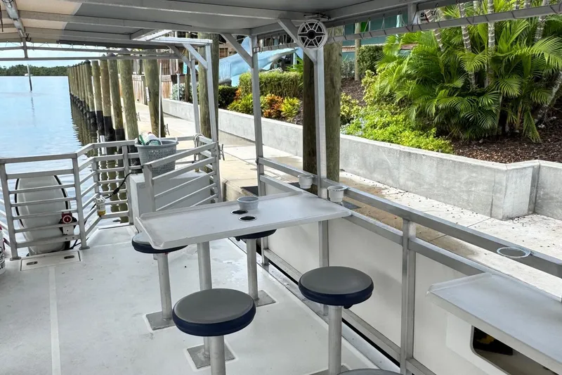 Slide: The Image of 2022 Guthrie Boatworks A&M Custom Pontoon with seating, docked by lush greenery. - 26