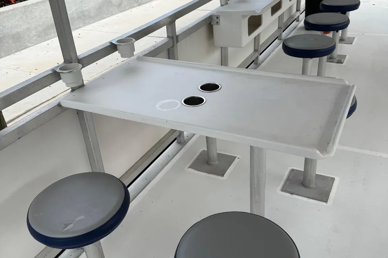 Slide: The Image of Interior of 2022 Guthrie Boatworks A&M Custom Pontoon with seating and table setup. - 27