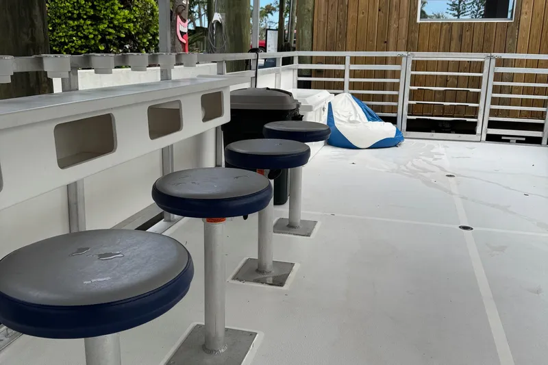 Slide: The Image of 2022 Guthrie Boatworks A&M Custom Pontoon interior with bar stools and spacious deck. - 28