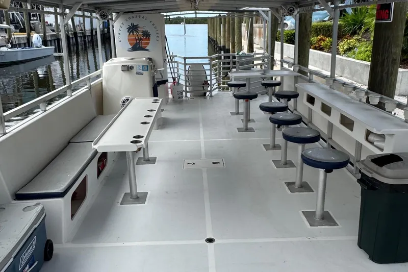 Slide: The Image of 2022 Guthrie Boatworks A&M Custom Pontoon with seating and tables, docked at marina. - 30