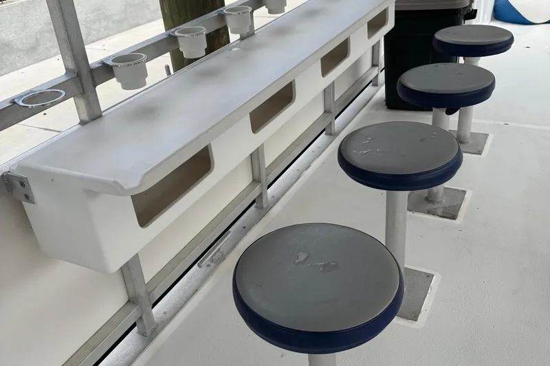 Slide: The Image of 2022 Guthrie Boatworks A&M Custom Pontoon seating area with stools and storage compartments. - 35