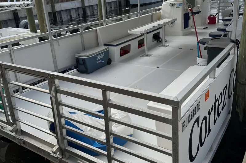 Slide: The Image of 2022 Guthrie Boatworks A&M Custom Pontoon docked, featuring spacious deck and seating. - 4