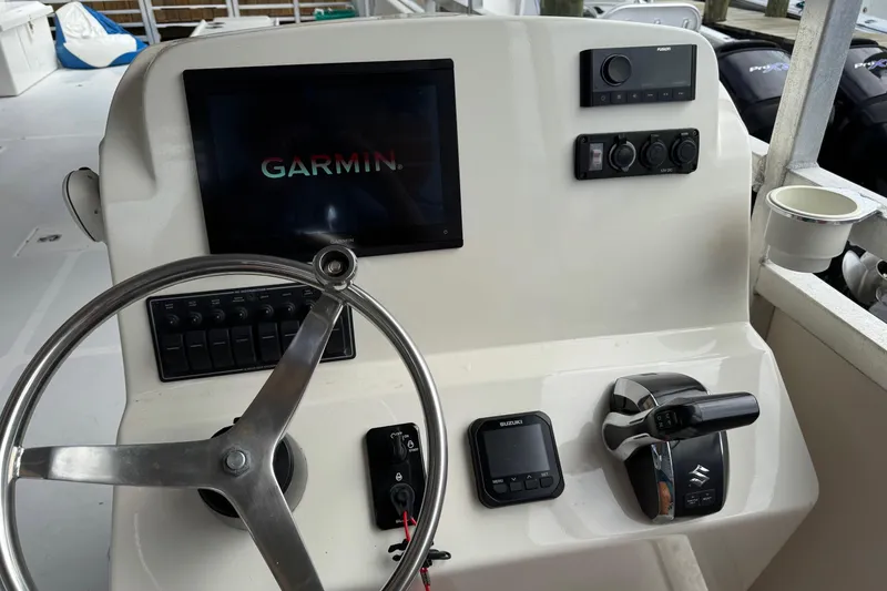 Slide: The Image of 2022 Guthrie Boatworks A&M Custom Pontoon dashboard with Garmin display and controls. - 44