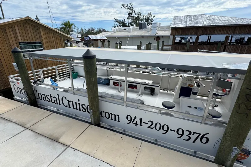 Slide: The Image of 2022 Guthrie Boatworks A&M Custom Pontoon docked, featuring Coastal Cruise branding. - 5