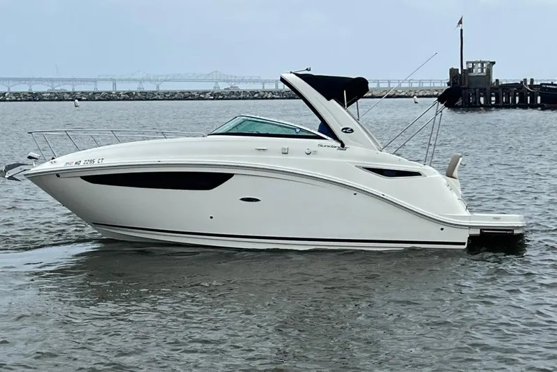 The Image of 2015 Sea Ray 260 Sundancer boat on calm water near a pier. - 1