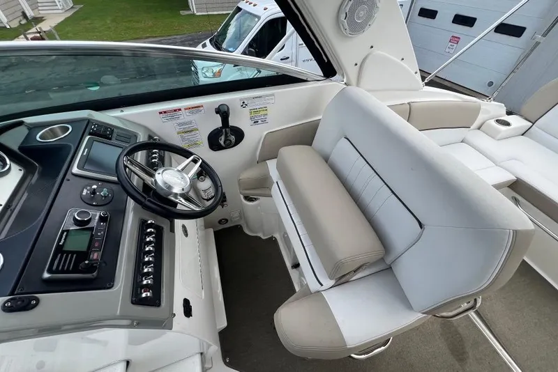 Slide: The Image of 2015 Sea Ray 260 Sundancer cockpit with steering wheel and seating area. - 11