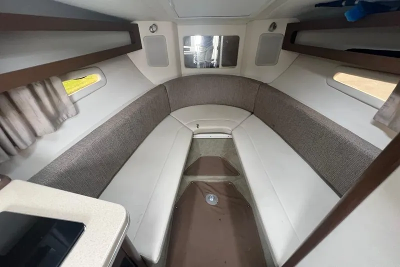 Slide: The Image of 2015 Sea Ray 260 Sundancer cabin interior with seating and windows. - 16