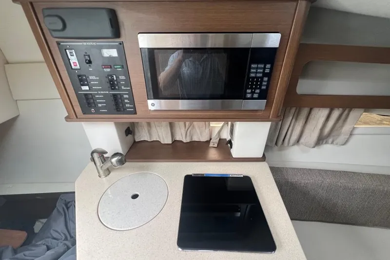 Slide: The Image of Interior of 2015 Sea Ray 260 Sundancer with microwave, control panel, and countertop. - 18