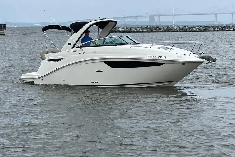 Slide: The Image of 2015 Sea Ray 260 Sundancer cruising on a calm waterway with a bridge in the background. - 4