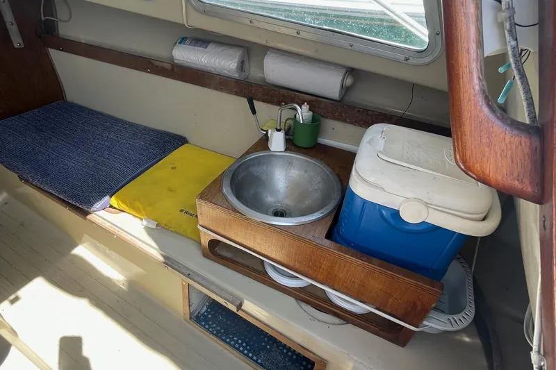 Slide: The Image of Interior of a Catalina 22 sailboat with sink, cooler, and seating area. - 10