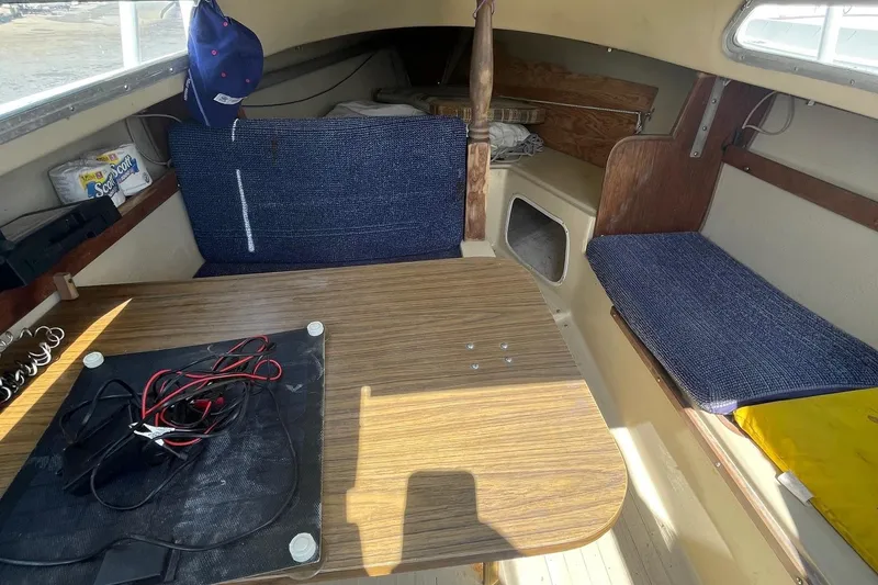 Slide: The Image of Interior of a Catalina 22 sailboat with wooden table and blue seating. - 11