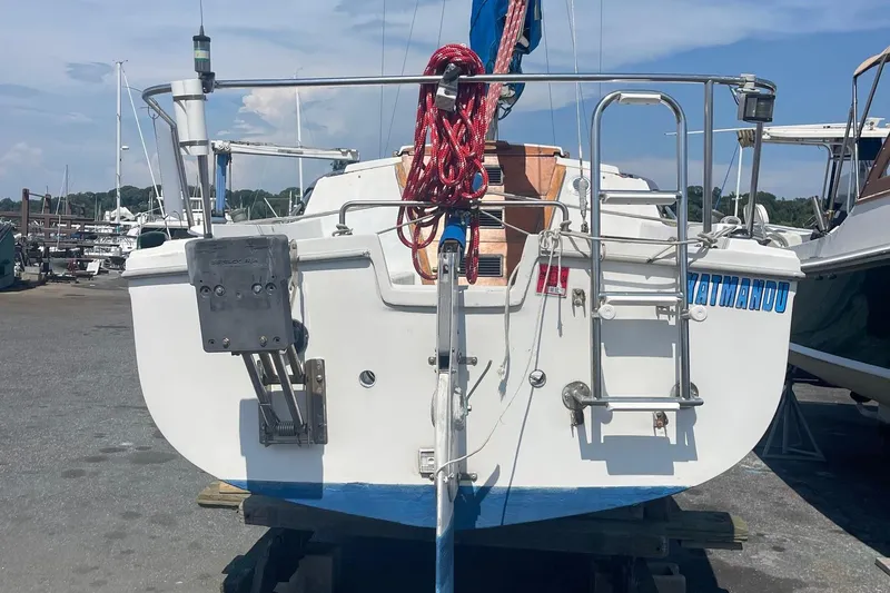 Slide: The Image of Catalina 22 sailboat stern view with ladder and red rope, docked on land. - 6
