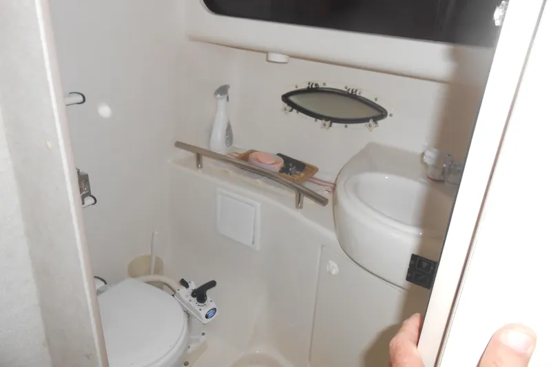 Slide: The Image of 1999 Bayliner 3055 Ciera boat bathroom with toilet, sink, and small window. - 13