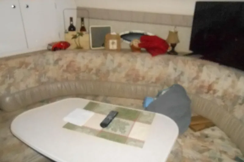 Slide: The Image of Interior of 1999 Bayliner 3055 Ciera with cozy seating and table setup. - 16