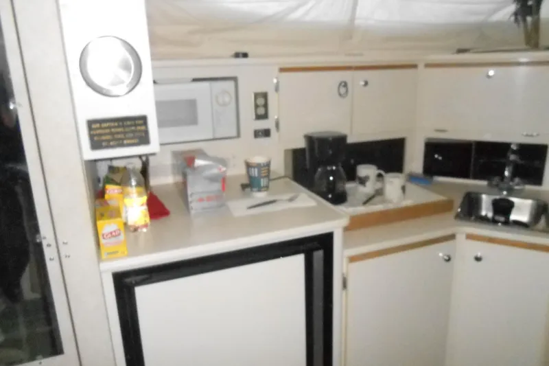 Slide: The Image of 1999 Bayliner 3055 Ciera kitchen area with microwave, coffee maker, and sink. - 17