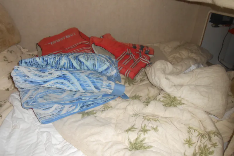 Slide: The Image of Interior of 1999 Bayliner 3055 Ciera with life jackets and patterned bedding. - 18