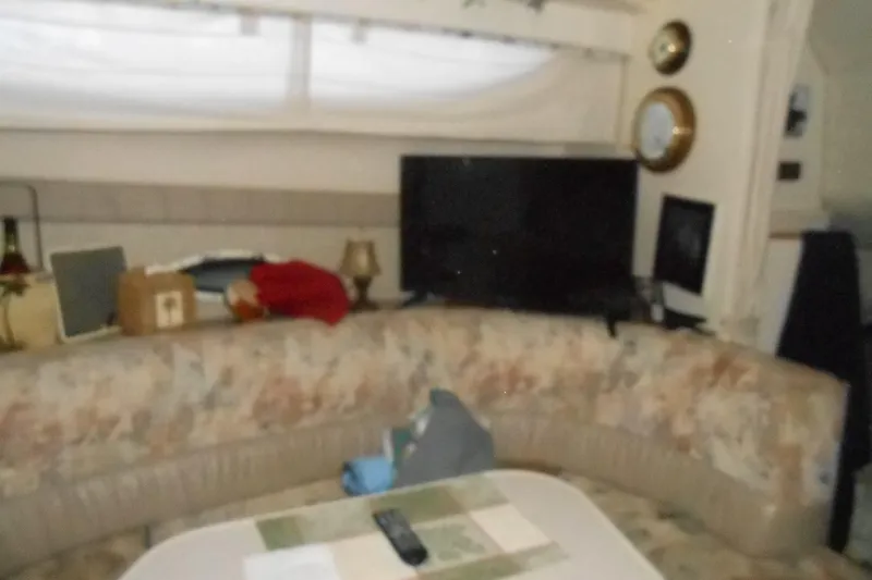 Slide: The Image of Interior of 1999 Bayliner 3055 Ciera with cozy seating and a TV setup. - 19