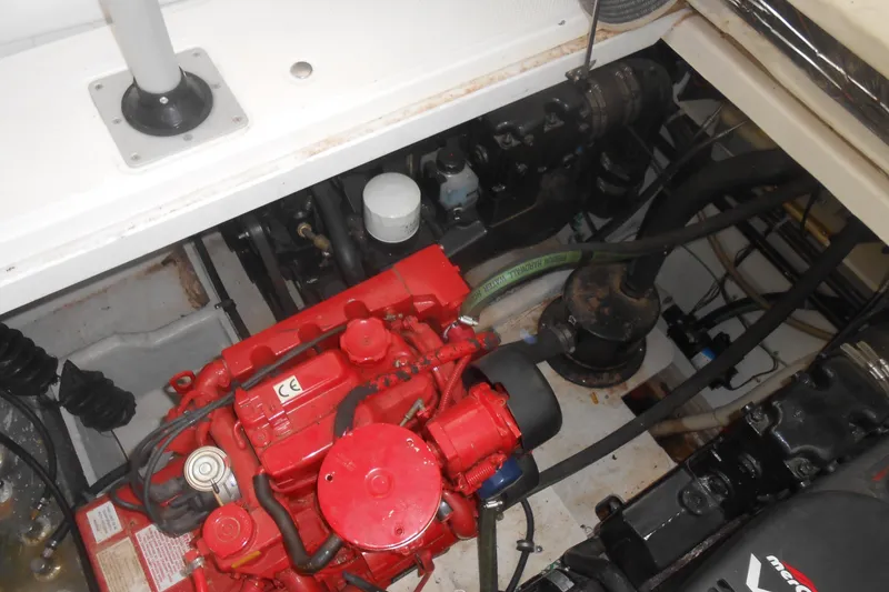 Slide: The Image of Engine compartment of a 1999 Bayliner 3055 Ciera boat, featuring a red engine. - 24