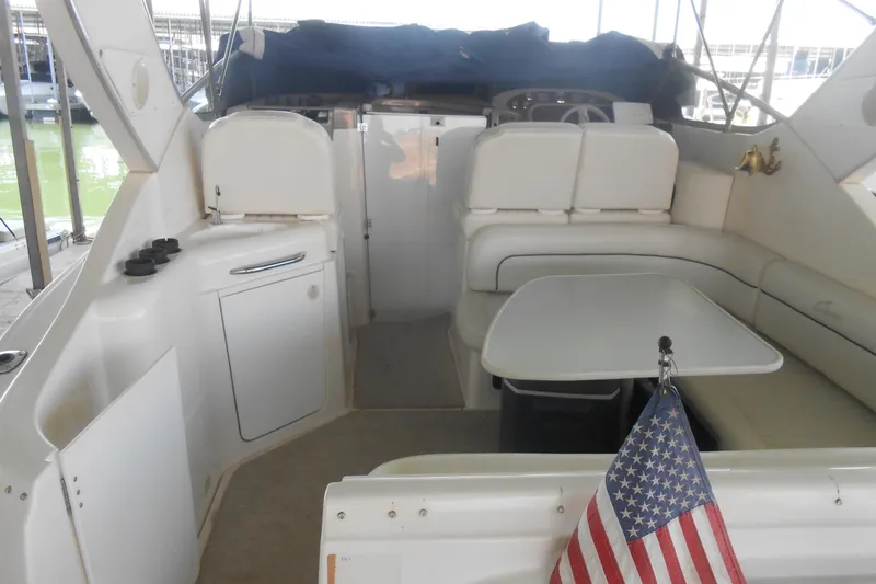Slide: The Image of 1999 Bayliner 3055 Ciera boat interior with seating, table, and American flag. - 5