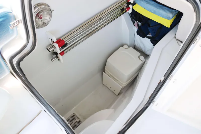 Slide: The Image of Compact cabin space in a 2007 Glacier Bay 2240 boat, featuring a portable toilet. - 10