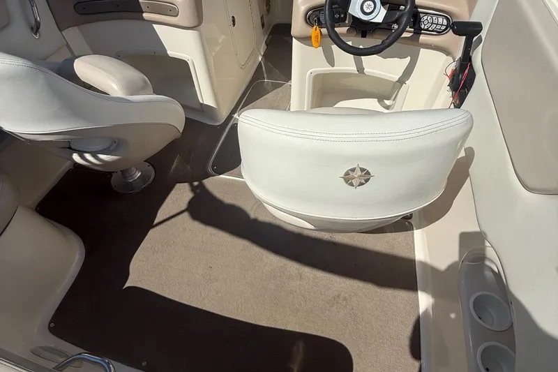 Slide: The Image of Interior of a 2005 Bryant 214 boat with beige seating and steering wheel. - 10