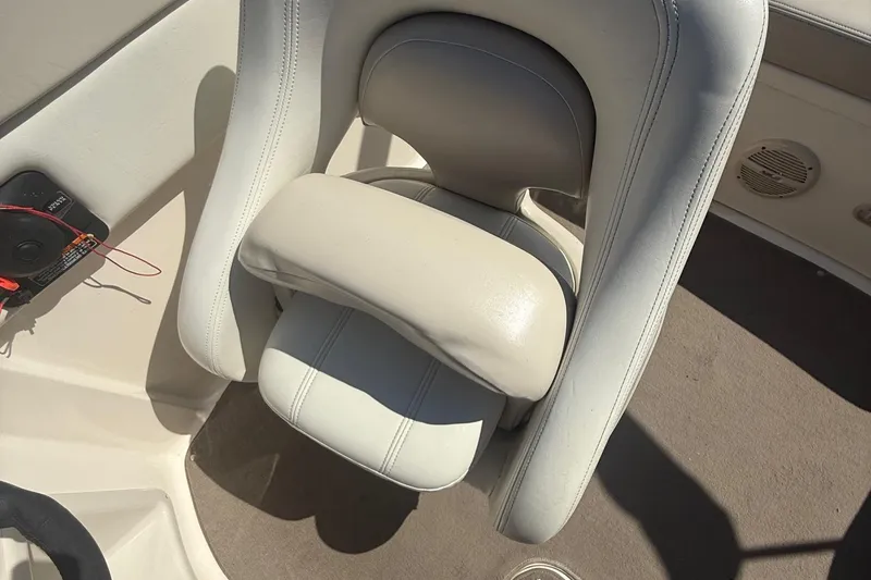 Slide: The Image of White leather boat seat in a 2005 Bryant 214, with visible speaker and control panel. - 13
