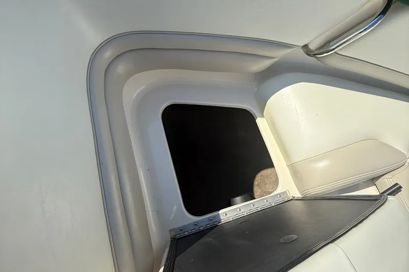 Slide: The Image of Open storage compartment on a 2005 Bryant 214 boat, featuring white and beige interior. - 23