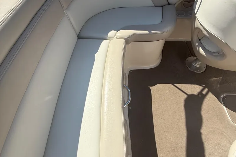 Slide: The Image of Interior of a 2005 Bryant 214 boat, featuring beige seating and carpet. - 30